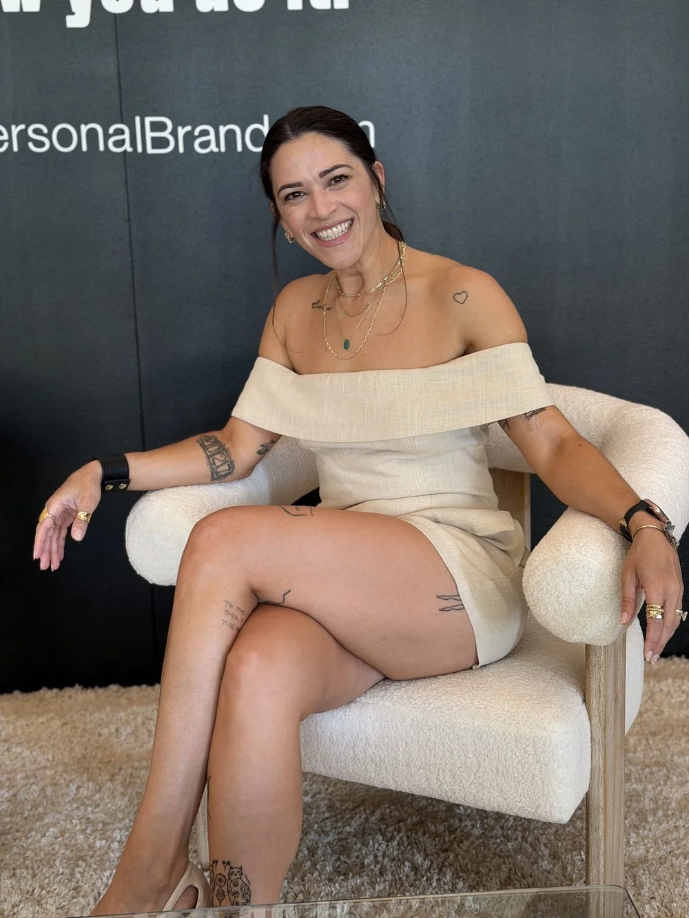 Liz smiling in a cream chair