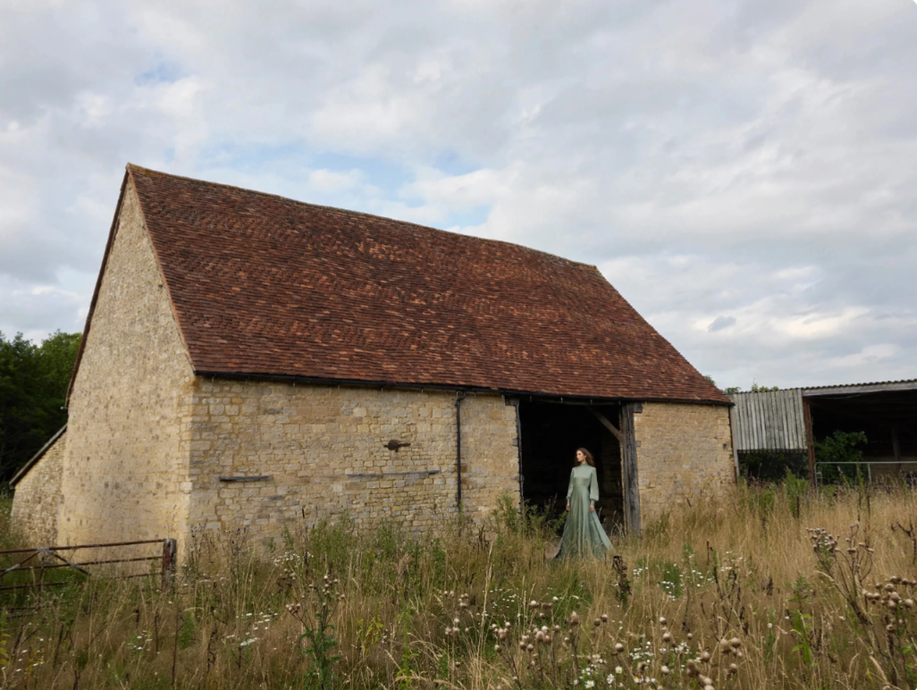 Stone barn set among wildflowers and long grass