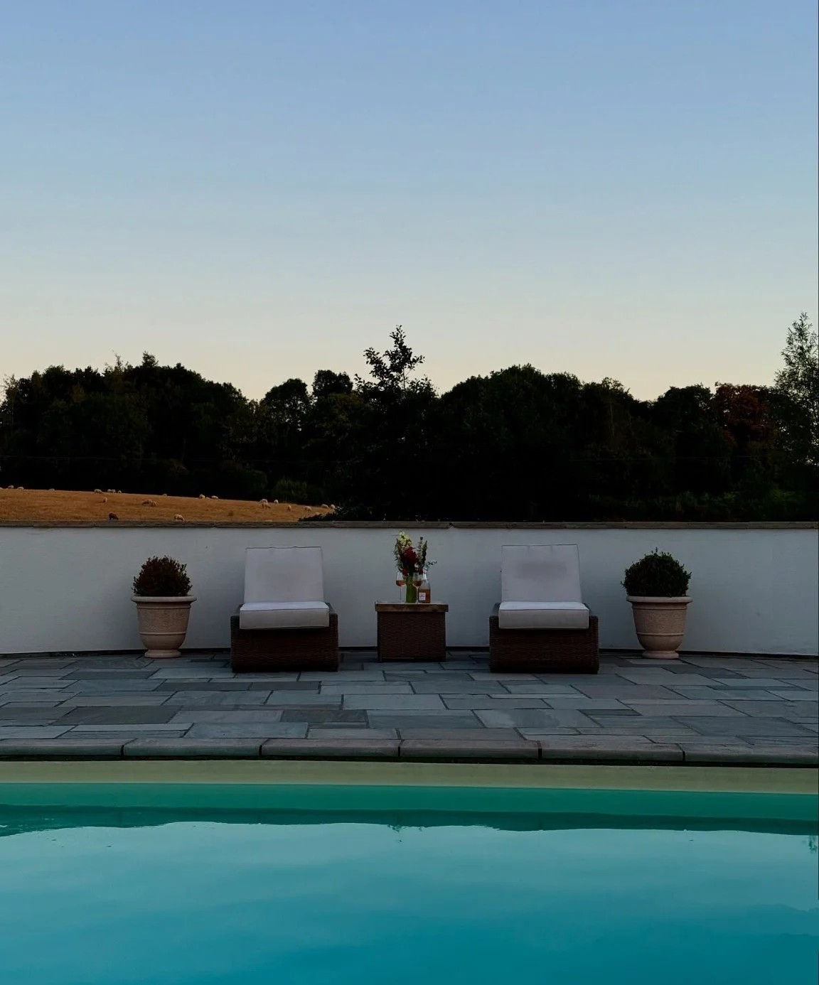 Two loungers beside the heated pool at dusk