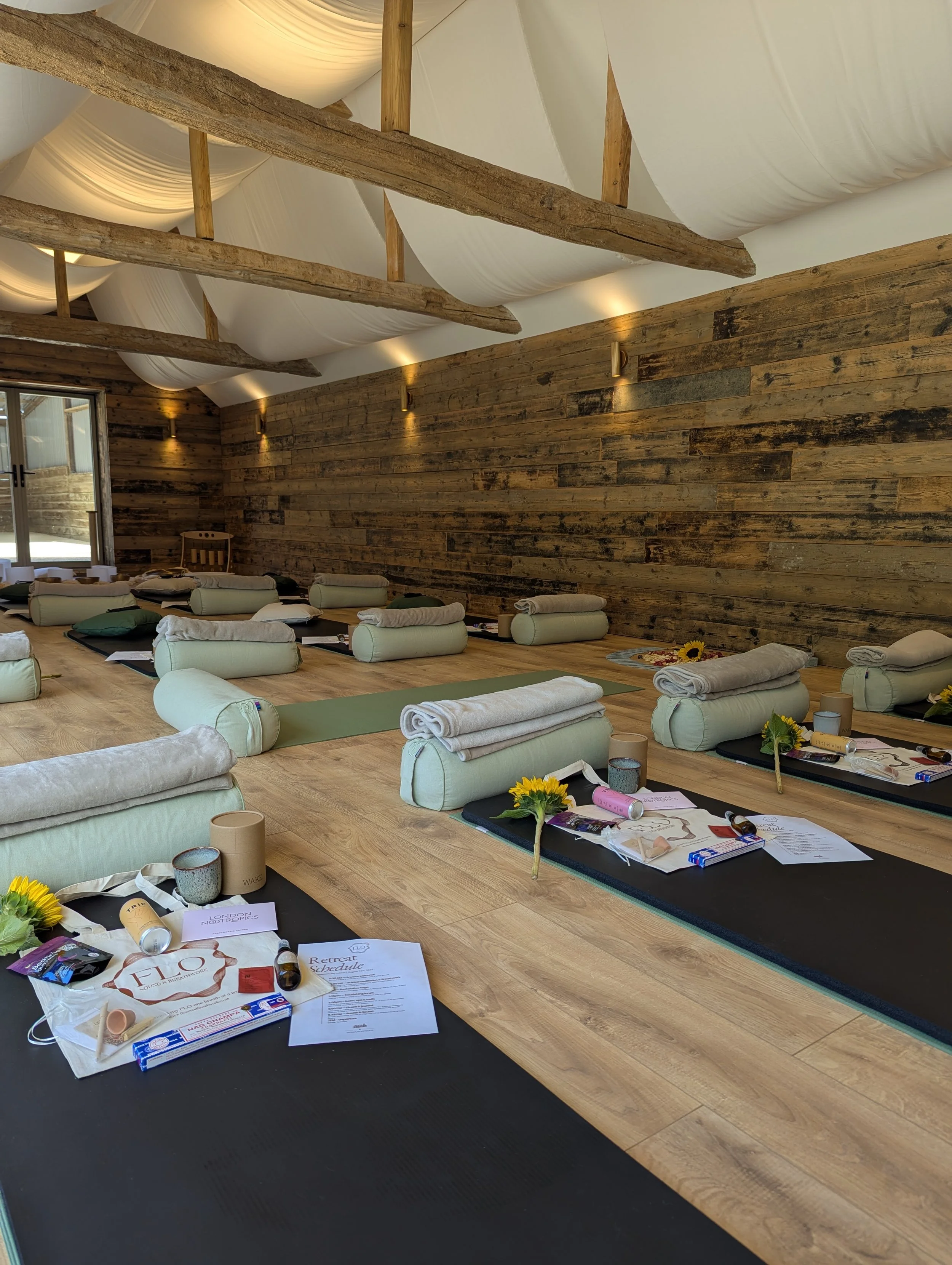 The studio set up for a sound and breathwork retreat with mats, bolsters and blankets