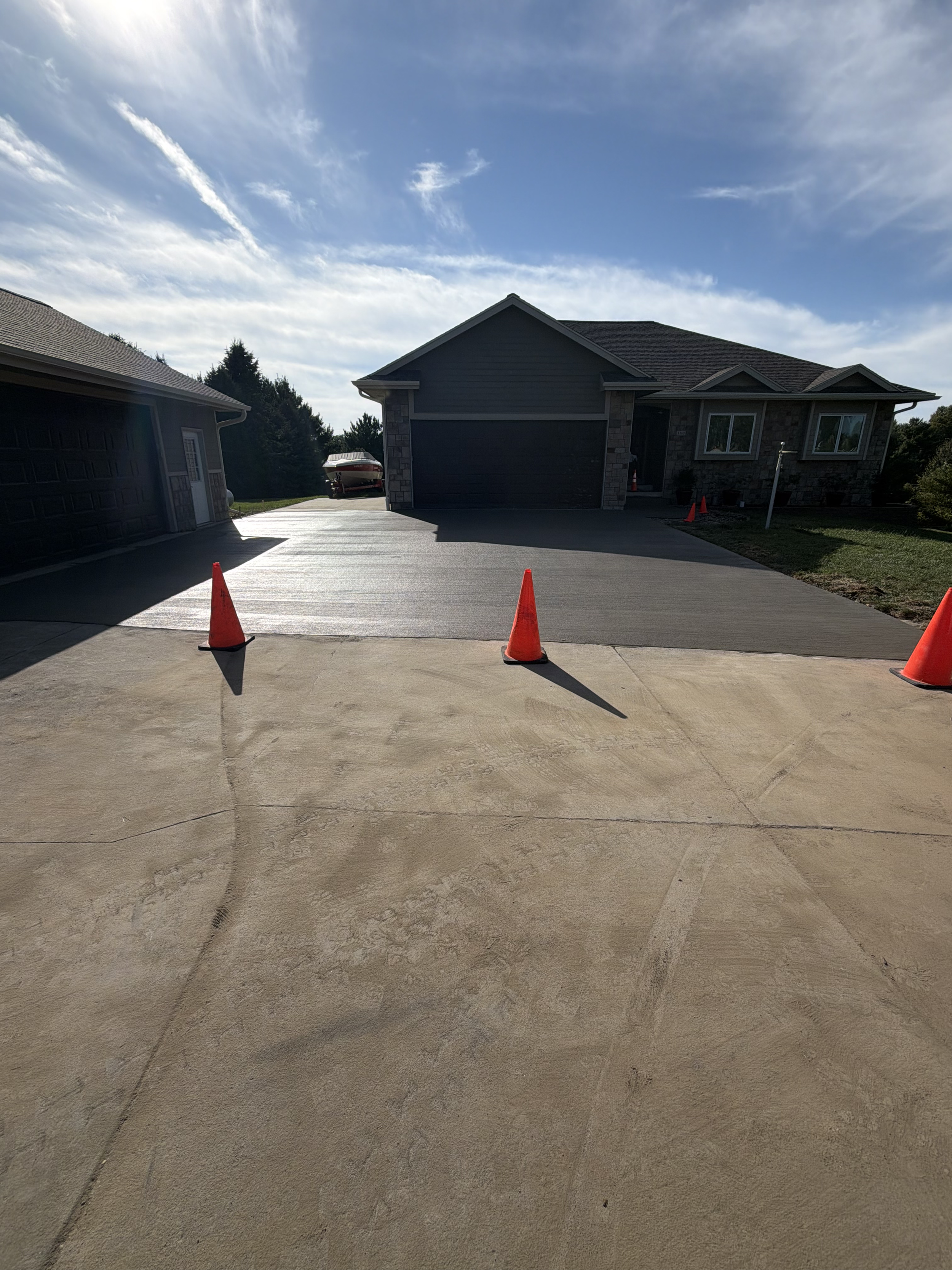 Workers framing fresh concrete driveway pad replacement
