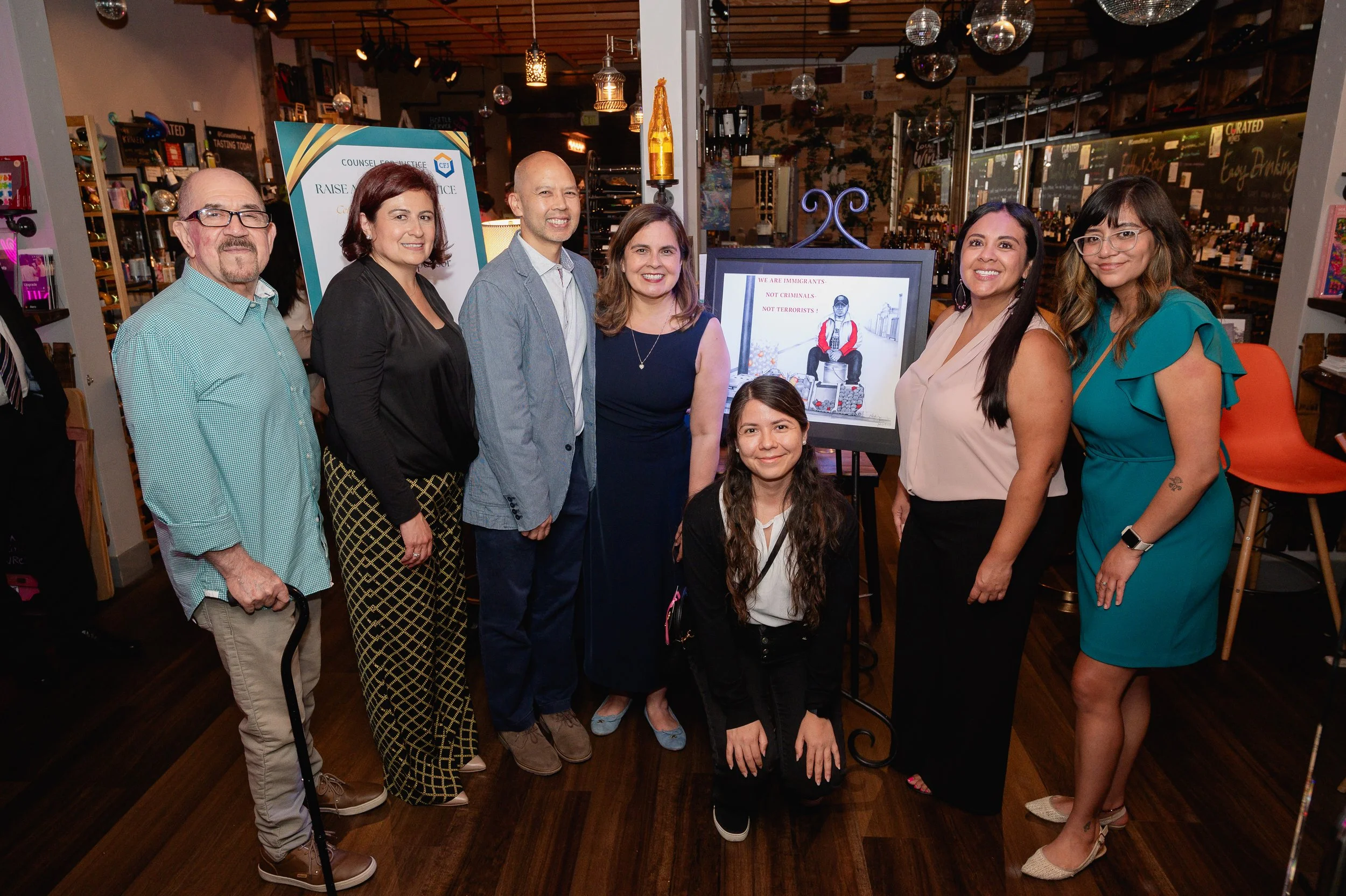 Smiling guests gather near the tasting table.