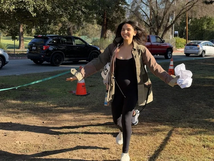 A smiling runner celebrates while crossing the finish