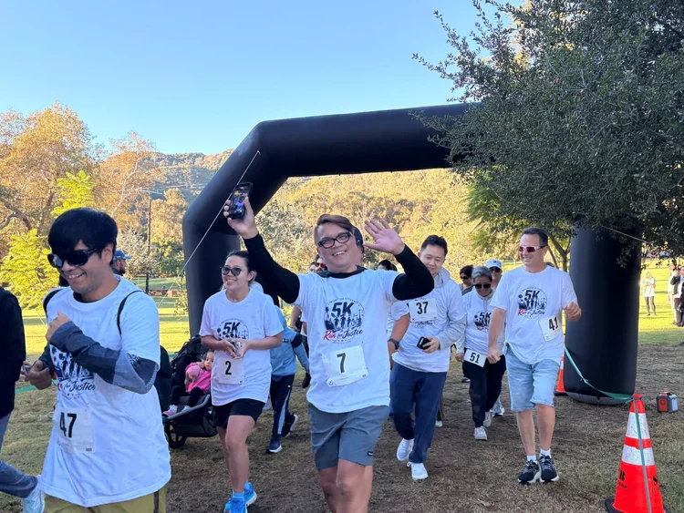 Runners wave and celebrate as they come through the 5K arch