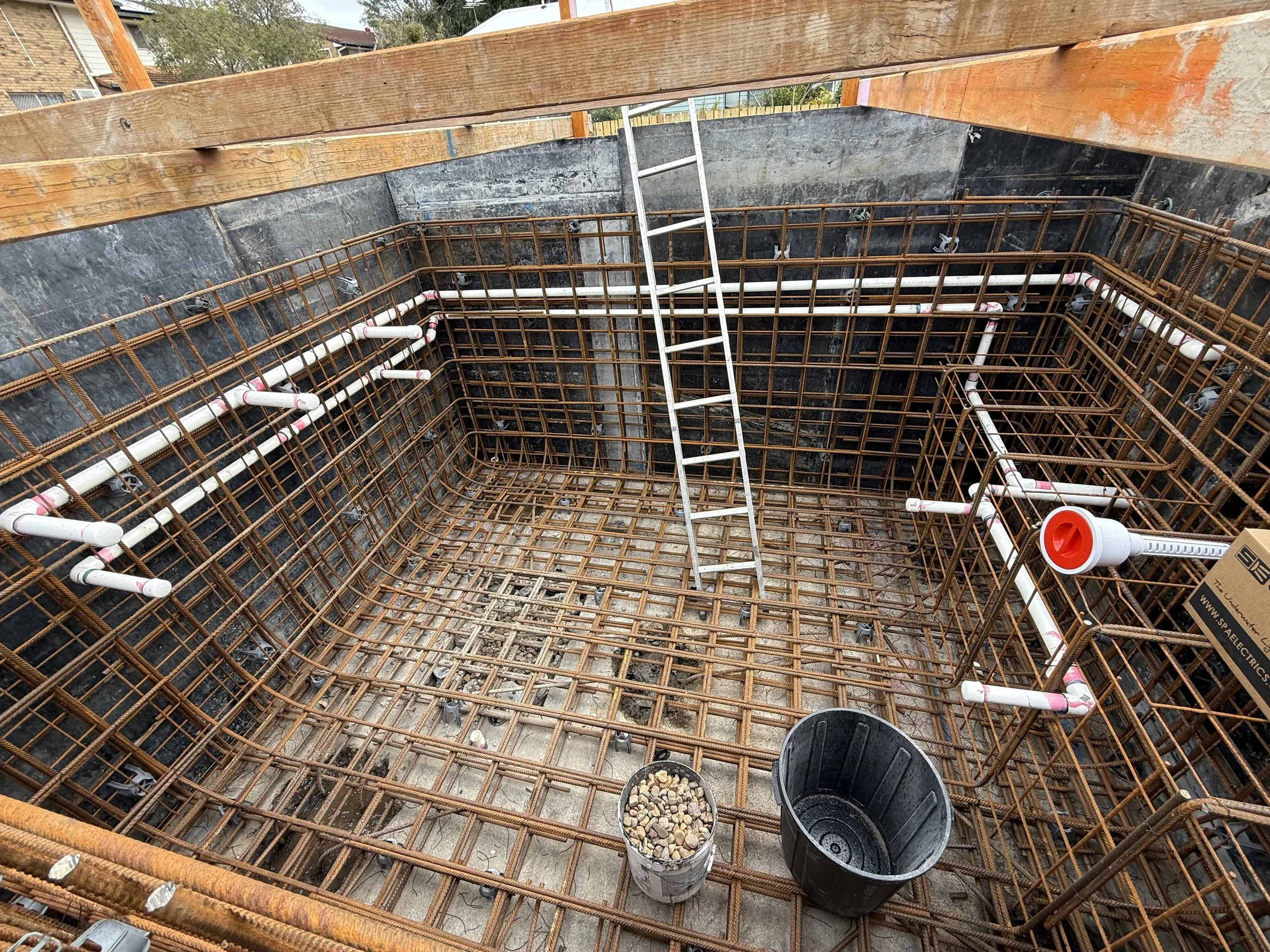 Suction and return lines run around the pool shell