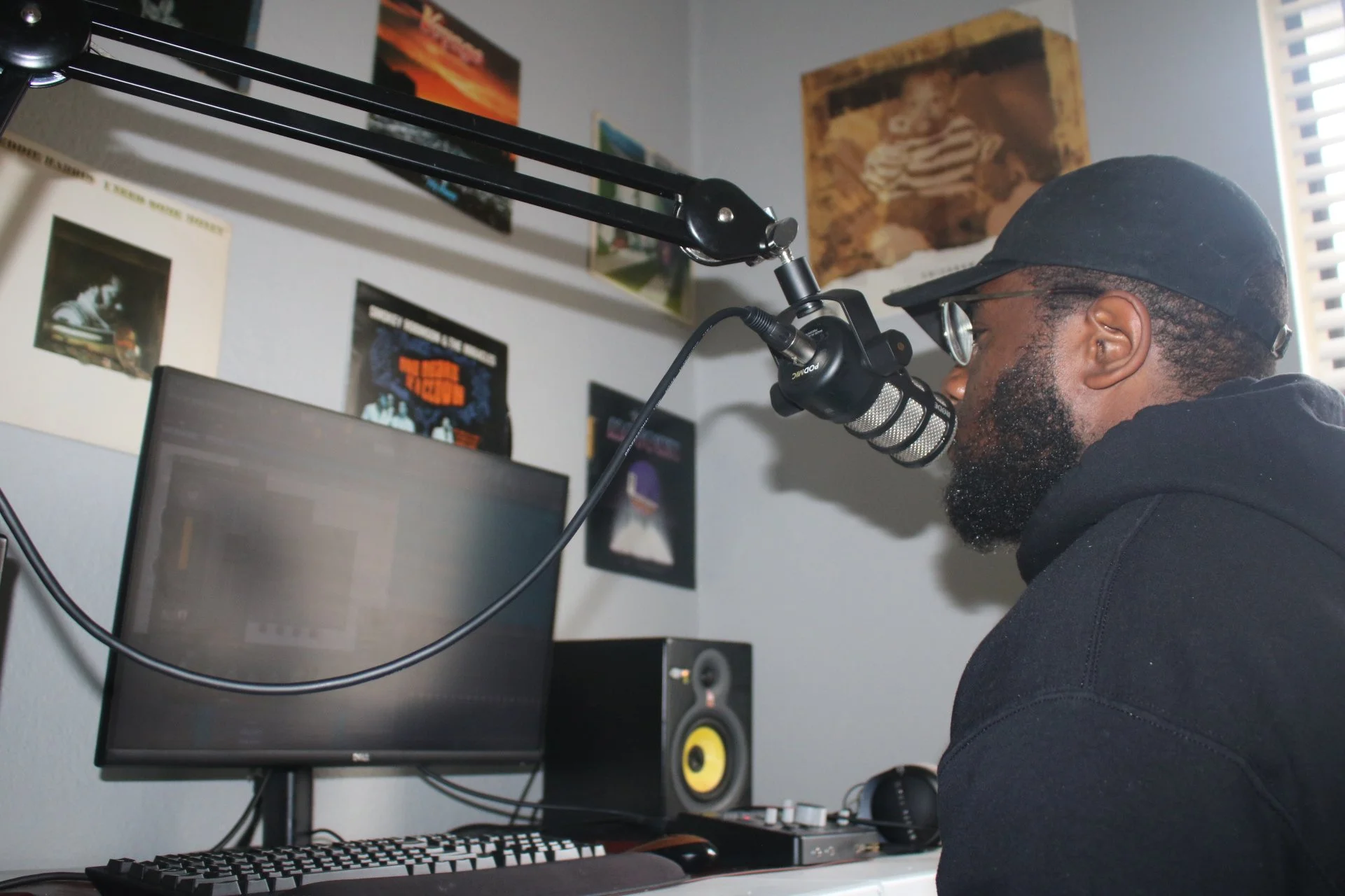 Chizabam working at the microphone and production desk in his studio
