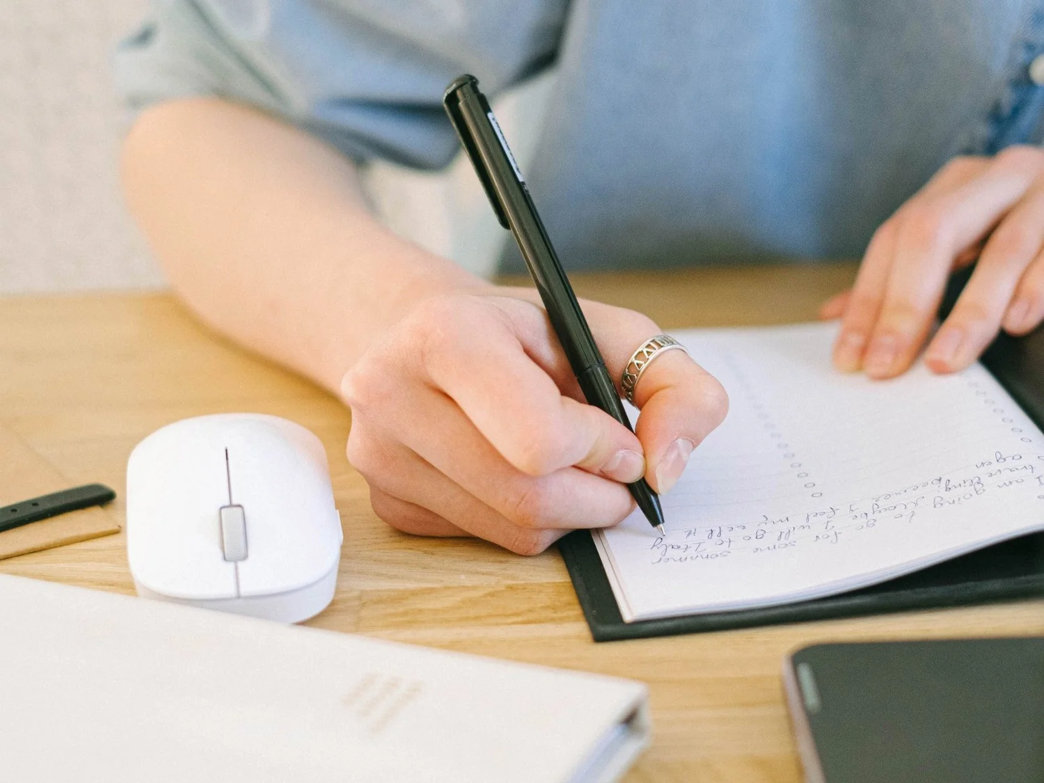 Mano escribiendo en un cuaderno
