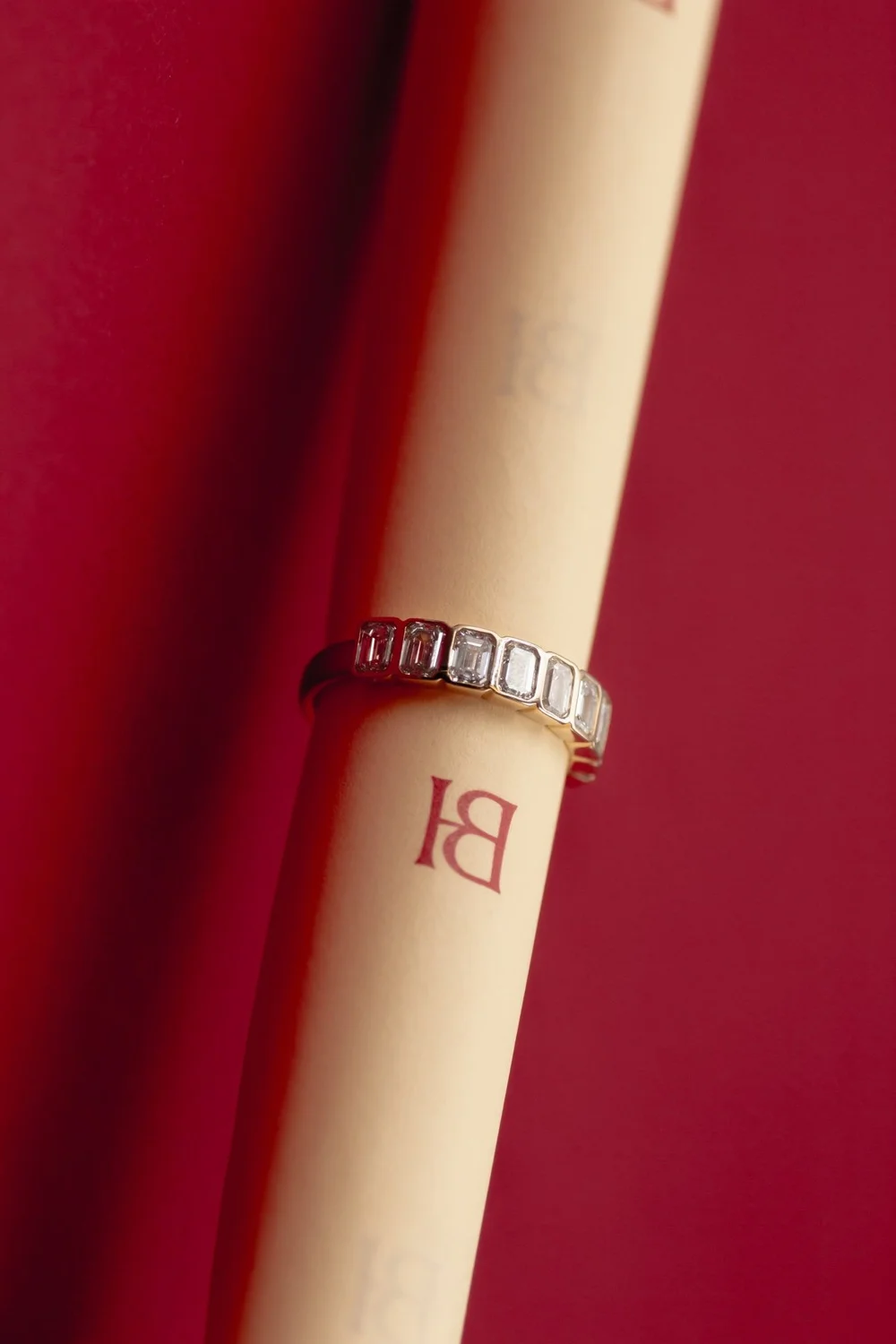 Nine emerald cut bezel diamonds set in a gold band