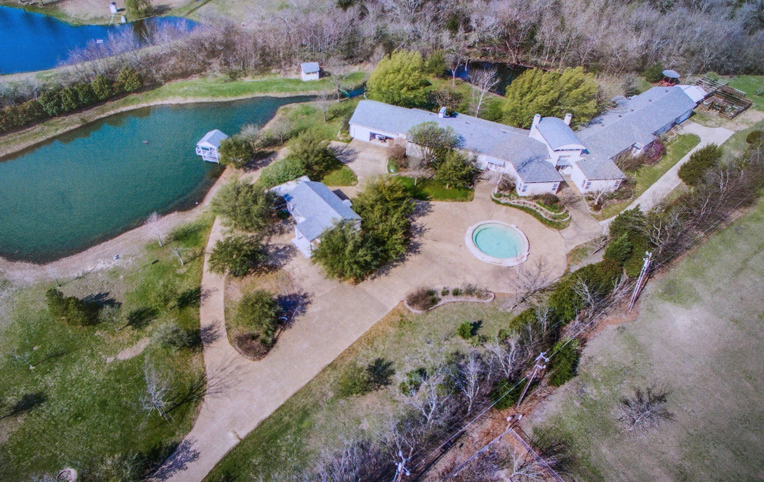 Outdoor waterfront wedding ceremony at The Ritz on Buffalo Creek — pond with floating fountain in Forney TX