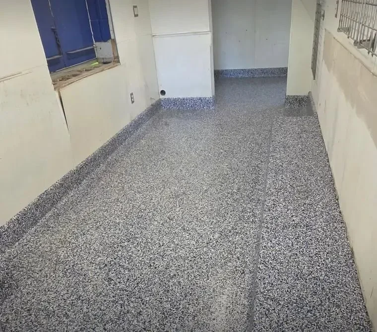 Quartz broadcast floor with cove base in a commercial corridor
