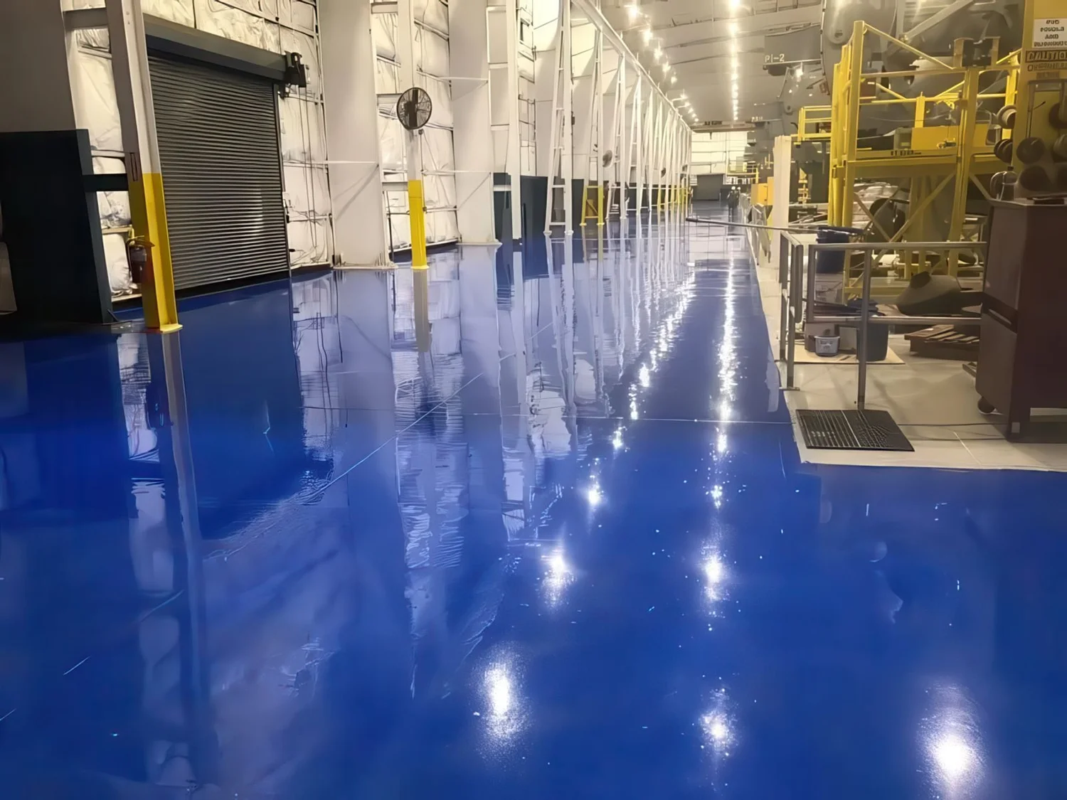 Seamless high-gloss blue resinous floor in an industrial production facility