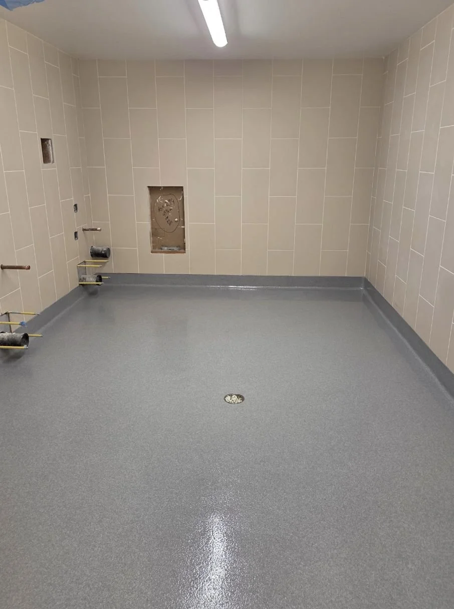 Seamless gray quartz shower room floor sloped to a center drain