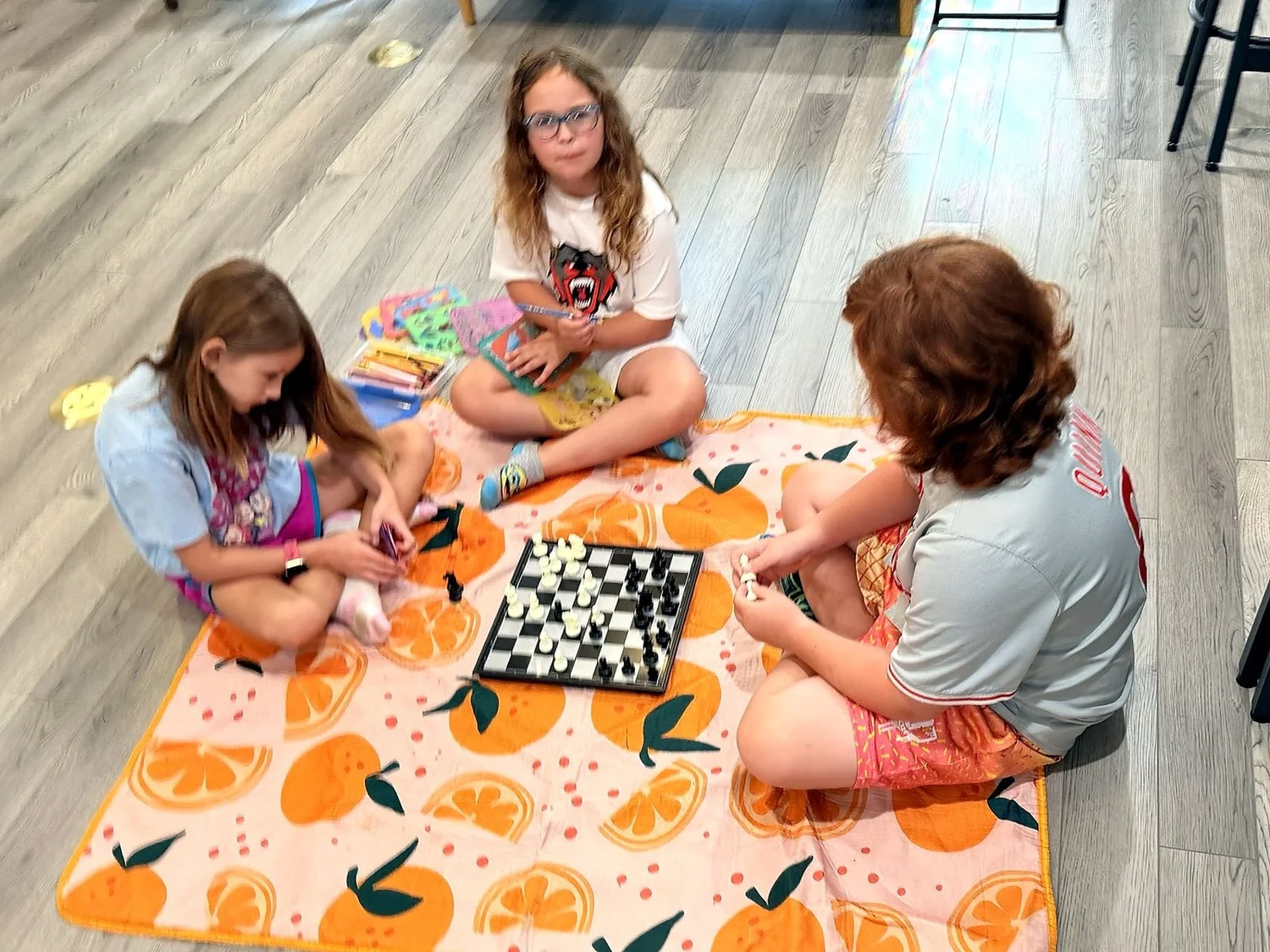 Kids playing chess together at the Clubhouse Game Table