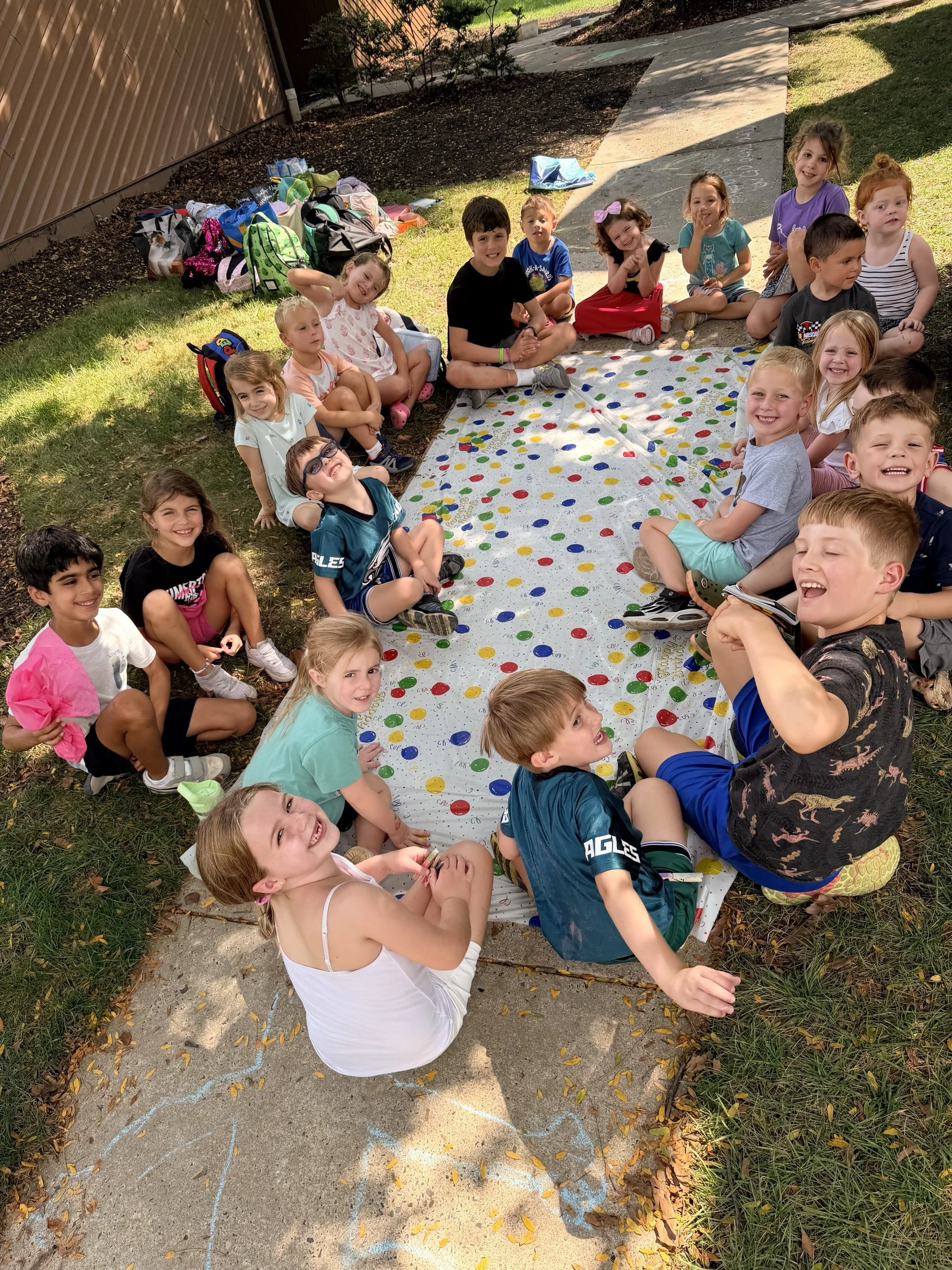 Kids sitting in a circle on the lawn during a Clubhouse day
