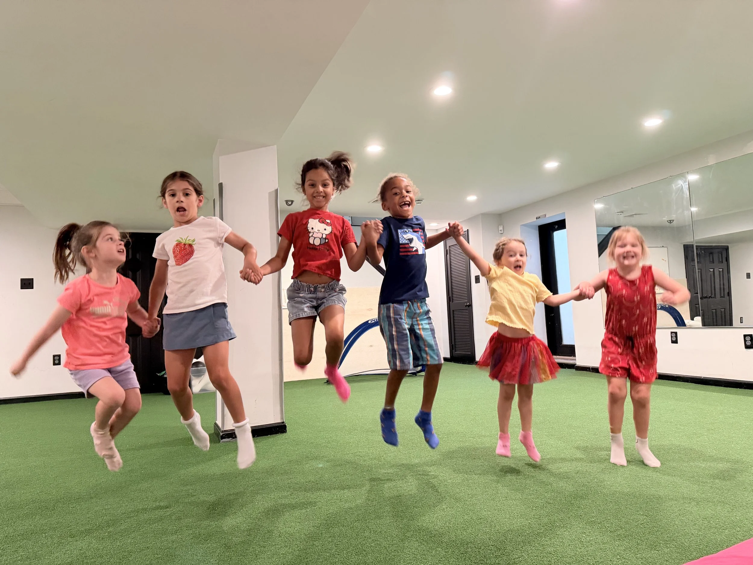Kids jumping and holding hands at The Clubhouse