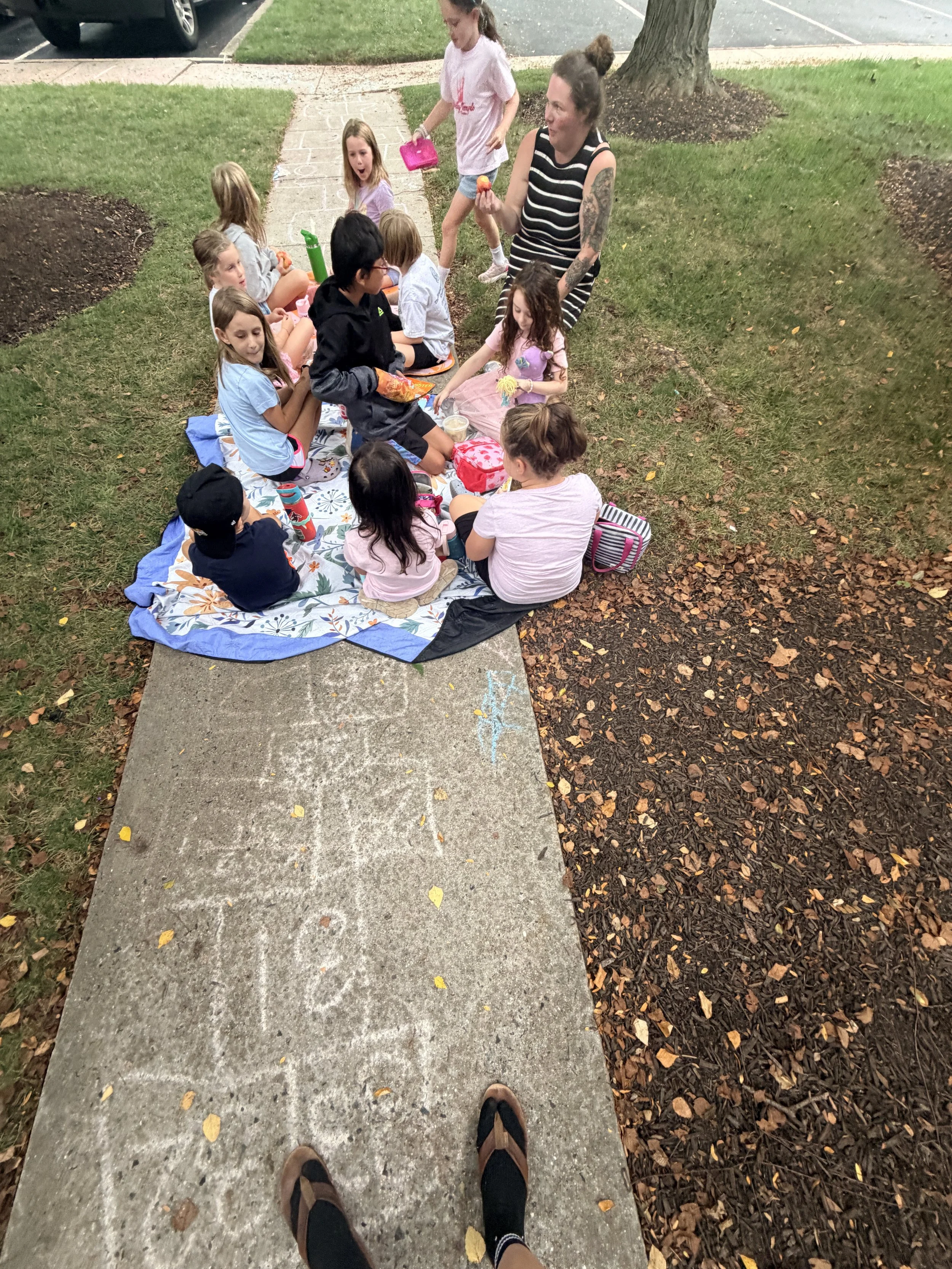 Campers eating lunch together outdoors at
      The Clubhouse Phoenixville summer camp