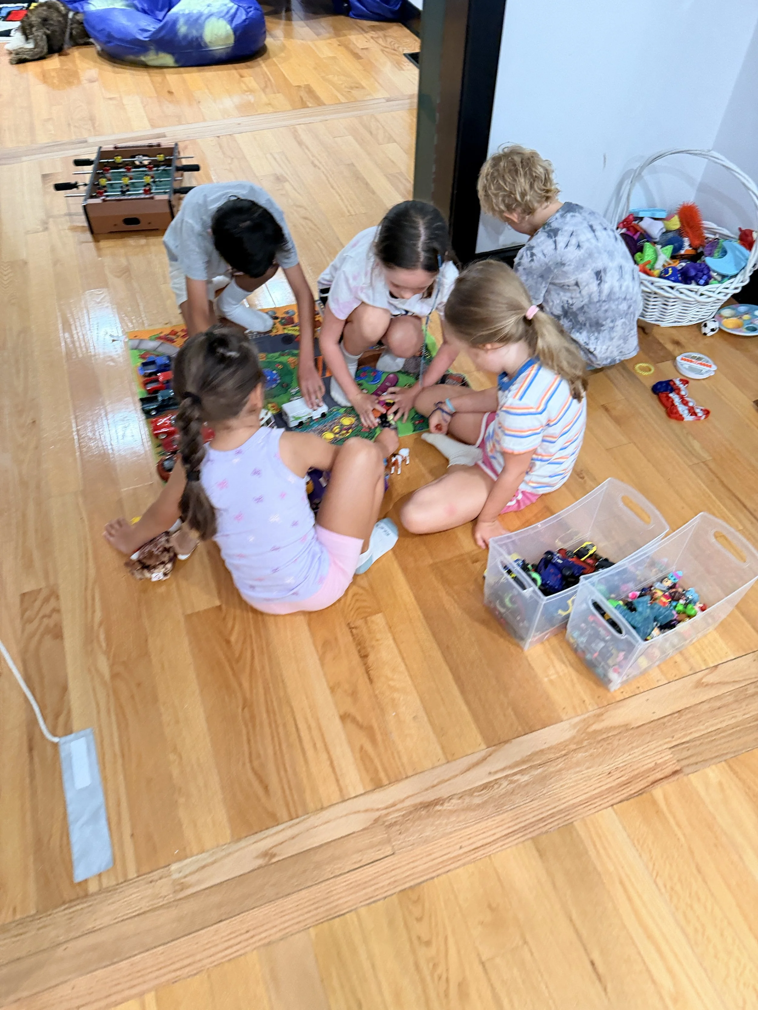Children playing with cars together on
    the floor at The Clubhouse Phoenixville