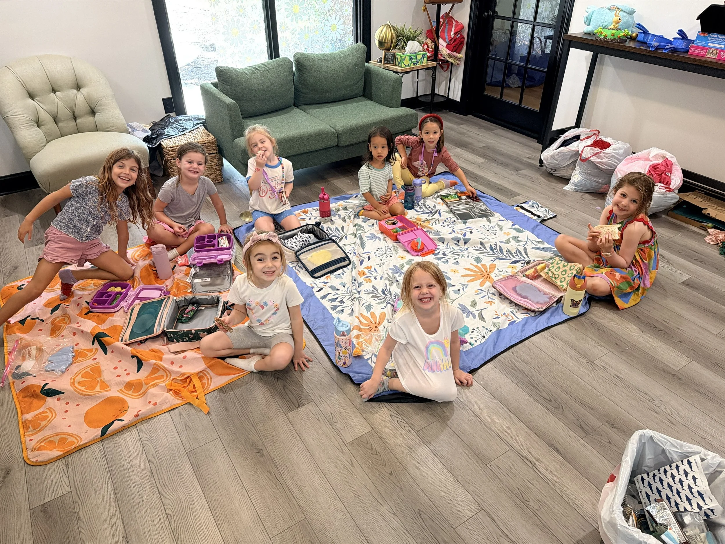 Kids eating lunch together on the picnic blanket