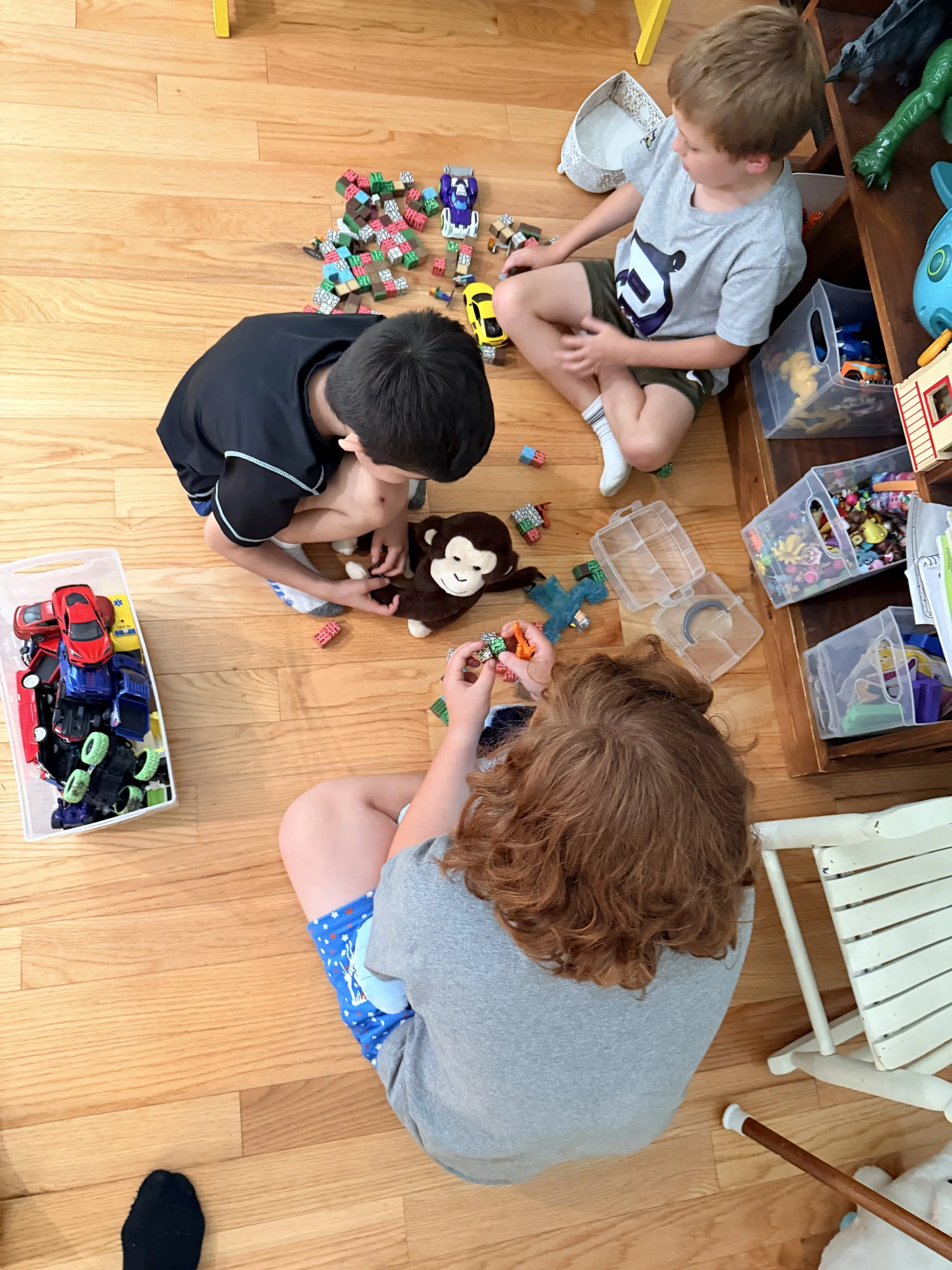 Children building with blocks and
      playing with cars on the floor at The Clubhouse Phoenixville