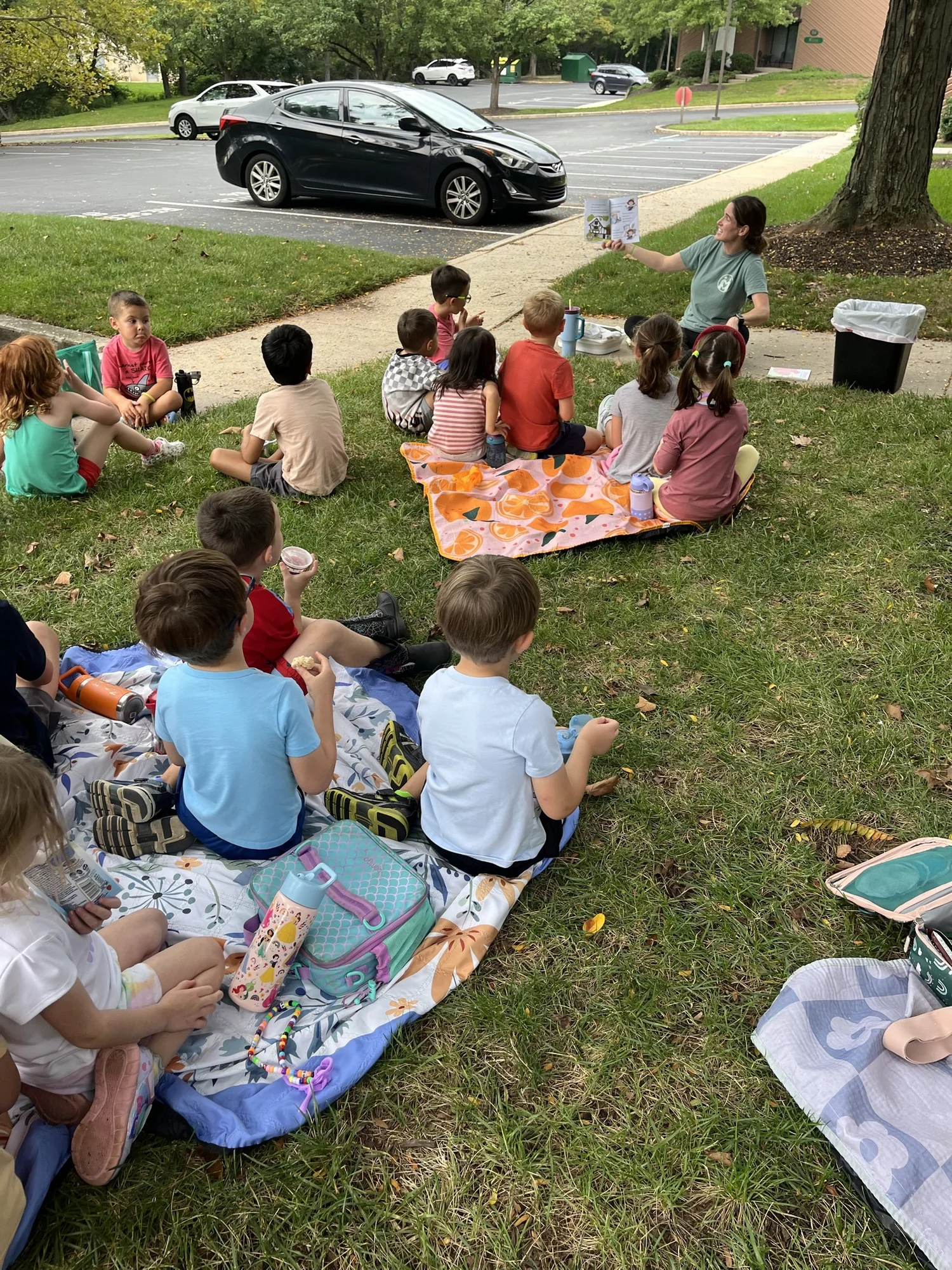 Nicole Weirich leading outdoor story time with kids at The Clubhouse