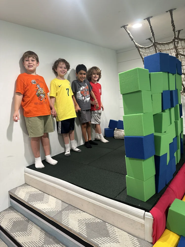 Boys building a tower of giant foam blocks at The Clubhouse