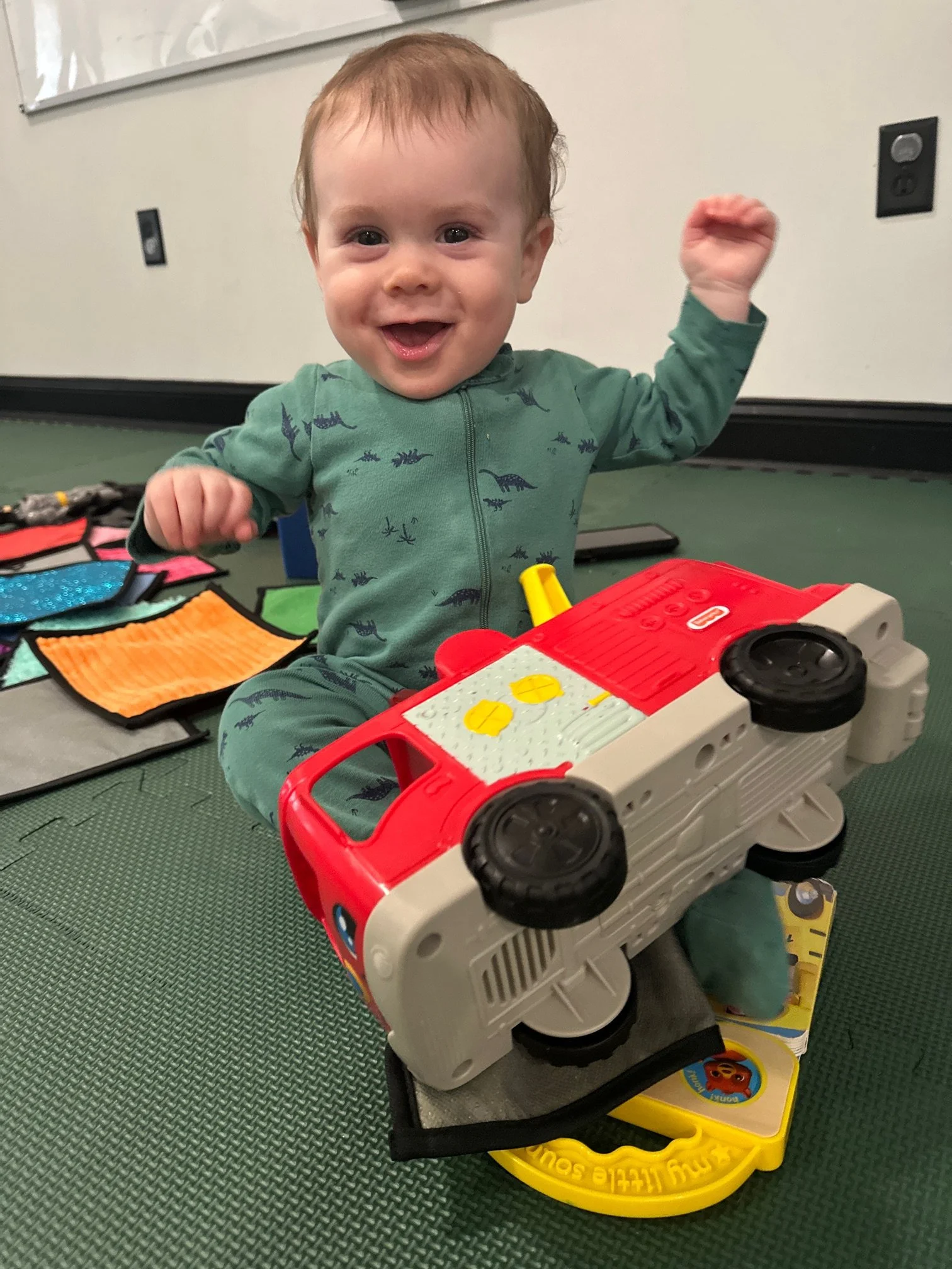 Smiling baby playing with toys during infant enrichment at The Clubhouse Phoenixville PA