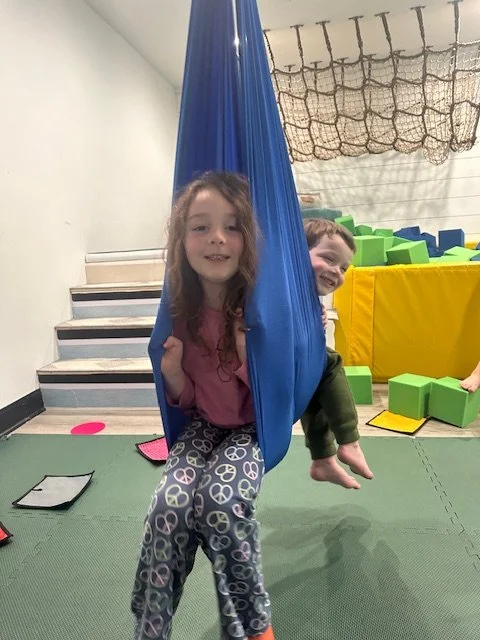 Kids playing on slide and hammock near foam pit at summer camp in Phoenixville PA