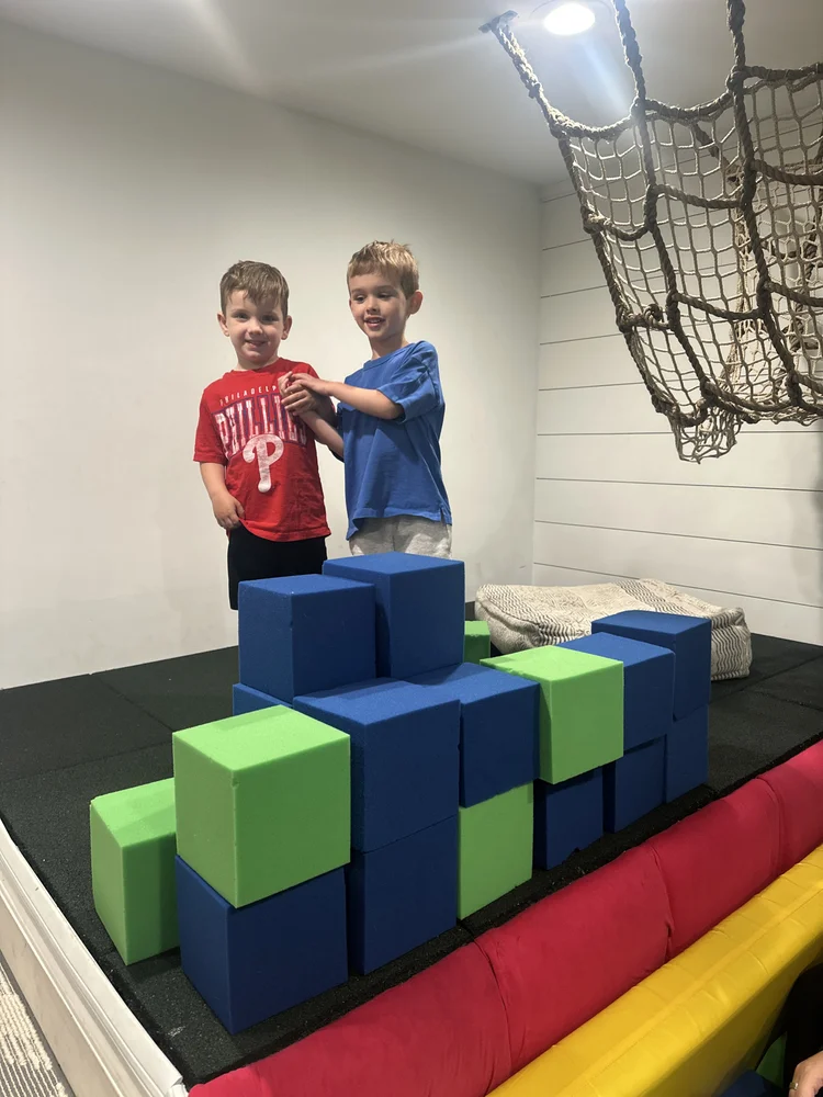 Boys building a wall of giant foam blocks together at The Clubhouse