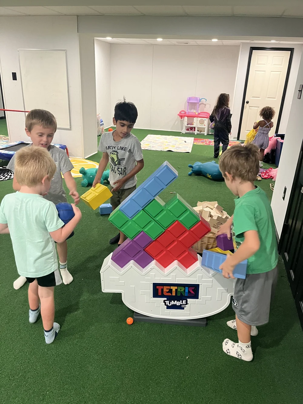 Kids playing a giant stacking block game together at The Clubhouse