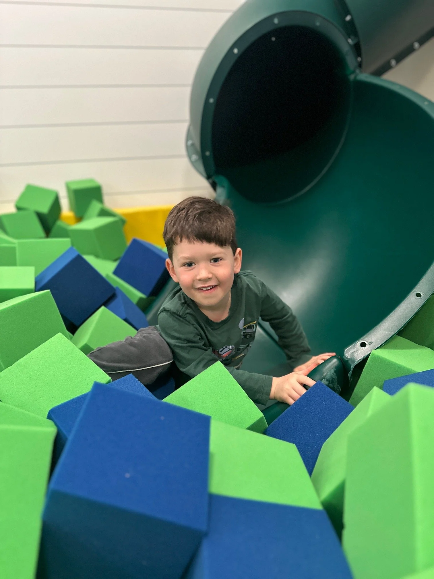 Kid sliding into foam pit at indoor playground The Clubhouse in Chester County PA
