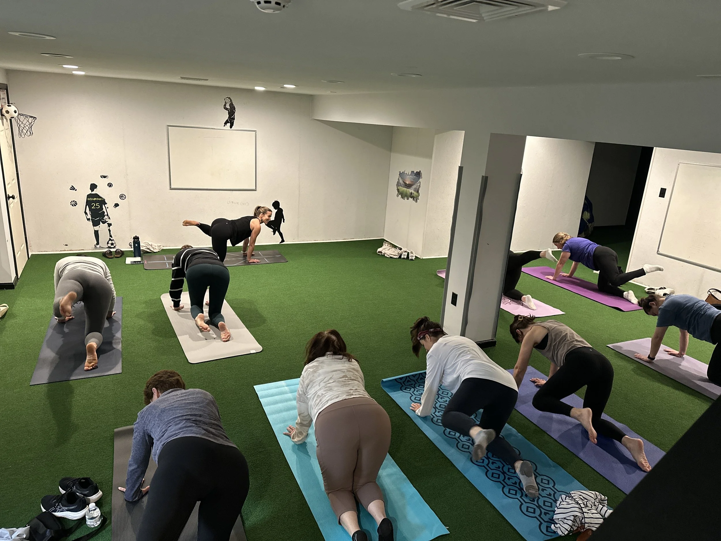 A yoga class on the turf area at The Clubhouse Phoenixville