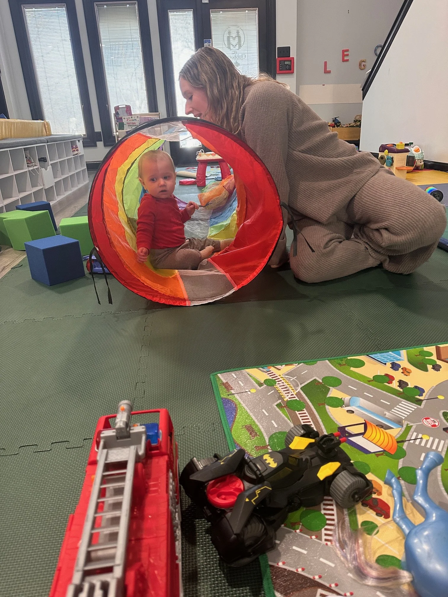 Mom and baby playing in tunnel during infant class at The Clubhouse Phoenixville PA
