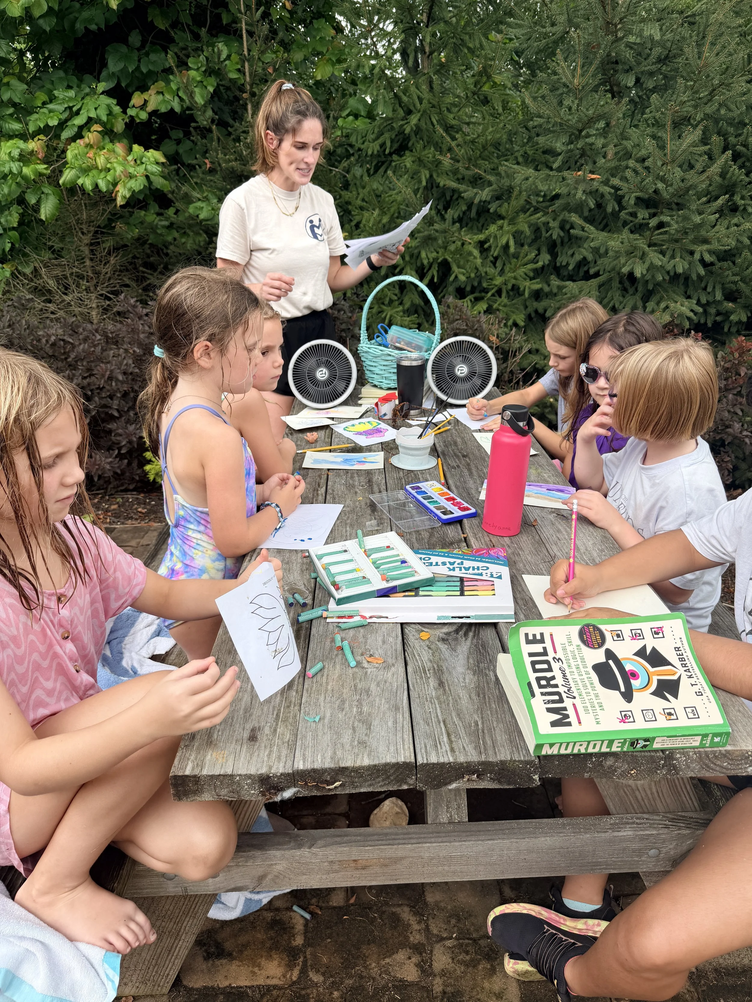 Kids painting with watercolours at an
    outdoor table during summer camp at The Clubhouse Phoenixville