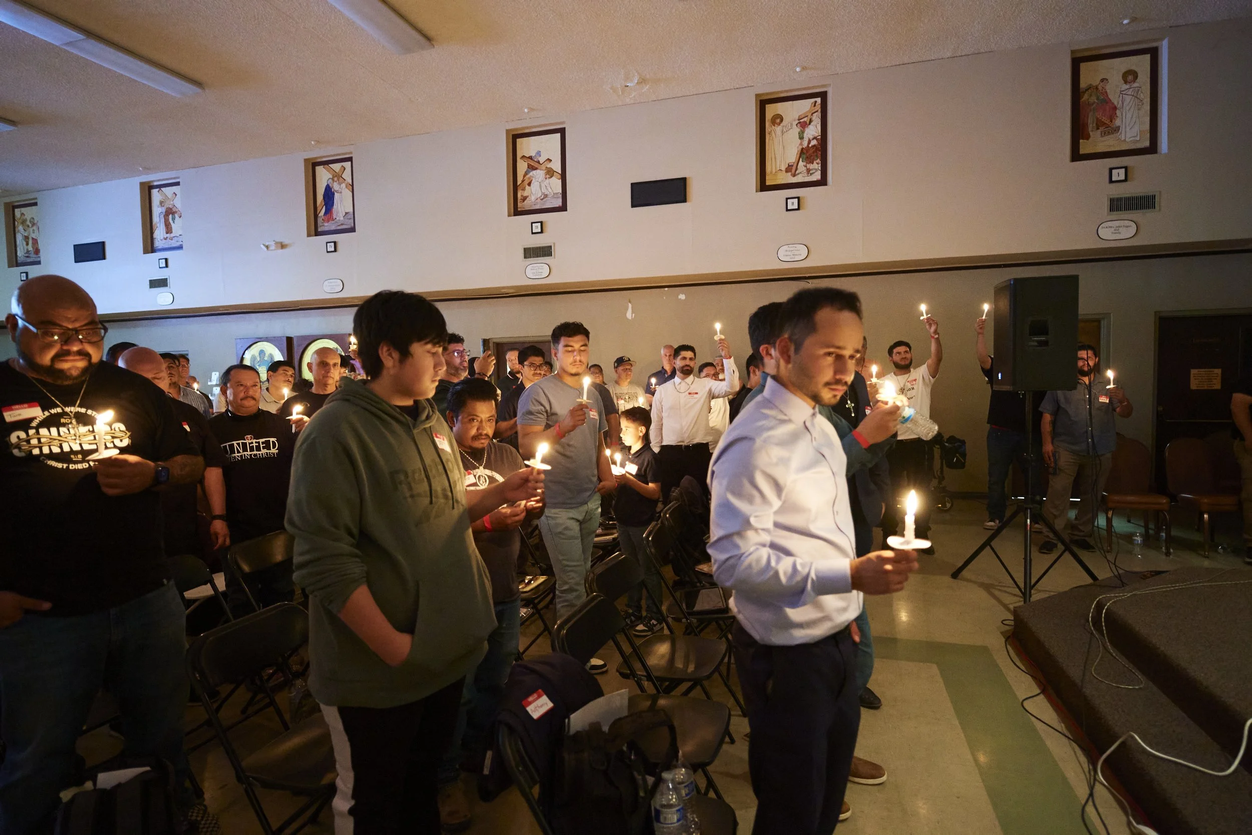Catholic men gathered together holding candles during a faith event