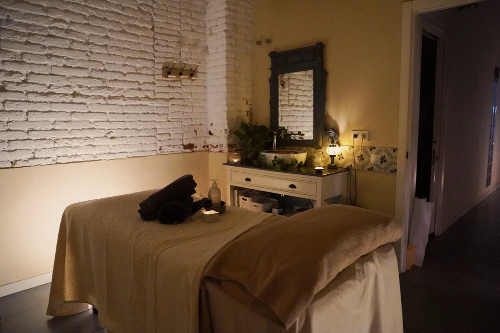 A candlelit CHYL treatment room with the massage table prepared