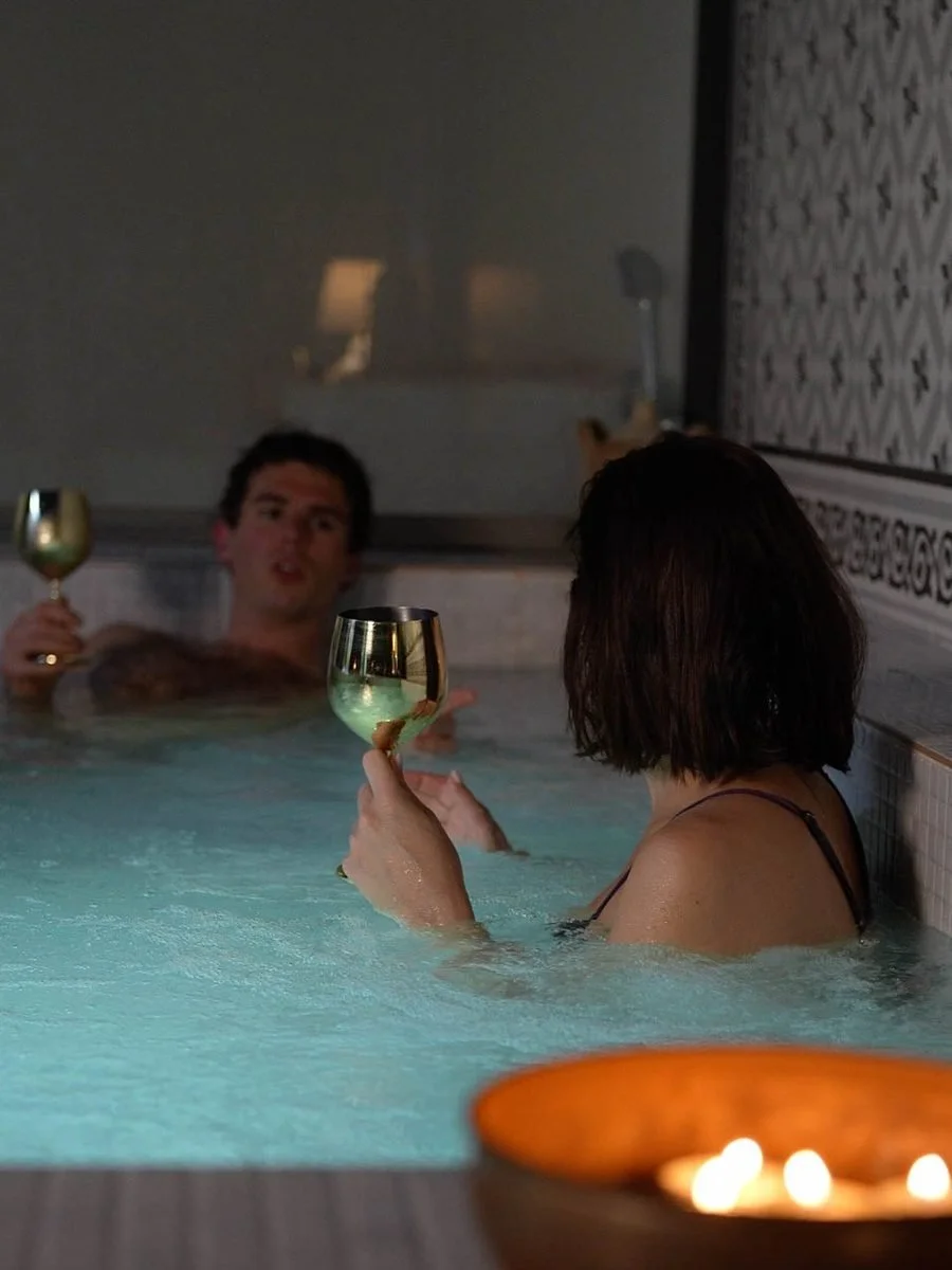 A couple with glasses of cava in the candlelit jacuzzi