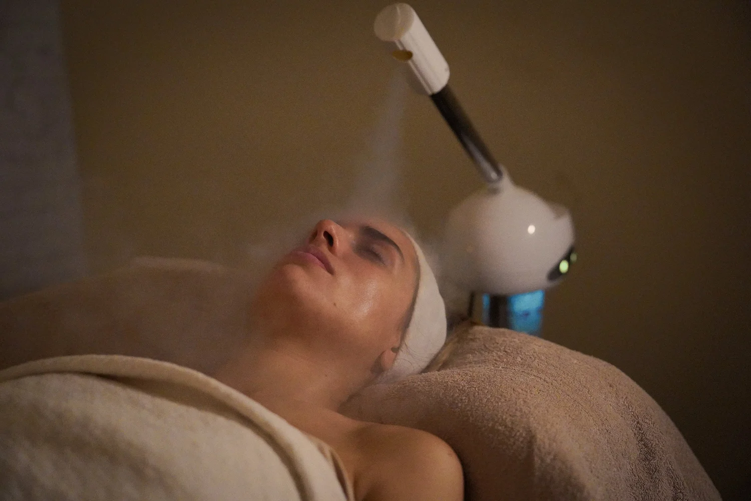 A guest relaxing under facial steam during her treatment