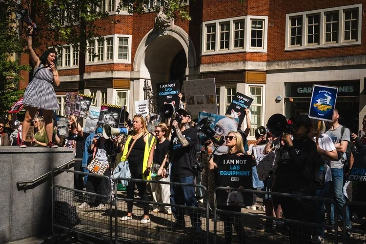 Crowd with megaphones and I am not lab equipment signs at a rally against animal experiments