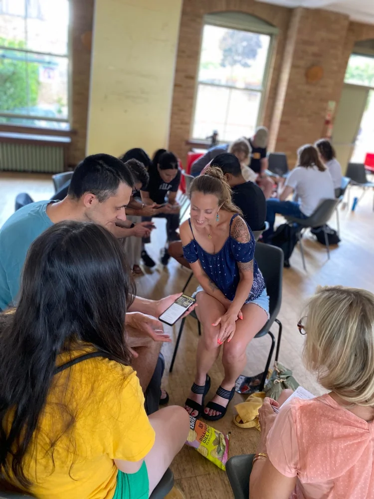 A smiling bootcamp attendee chatting in a small discussion circle