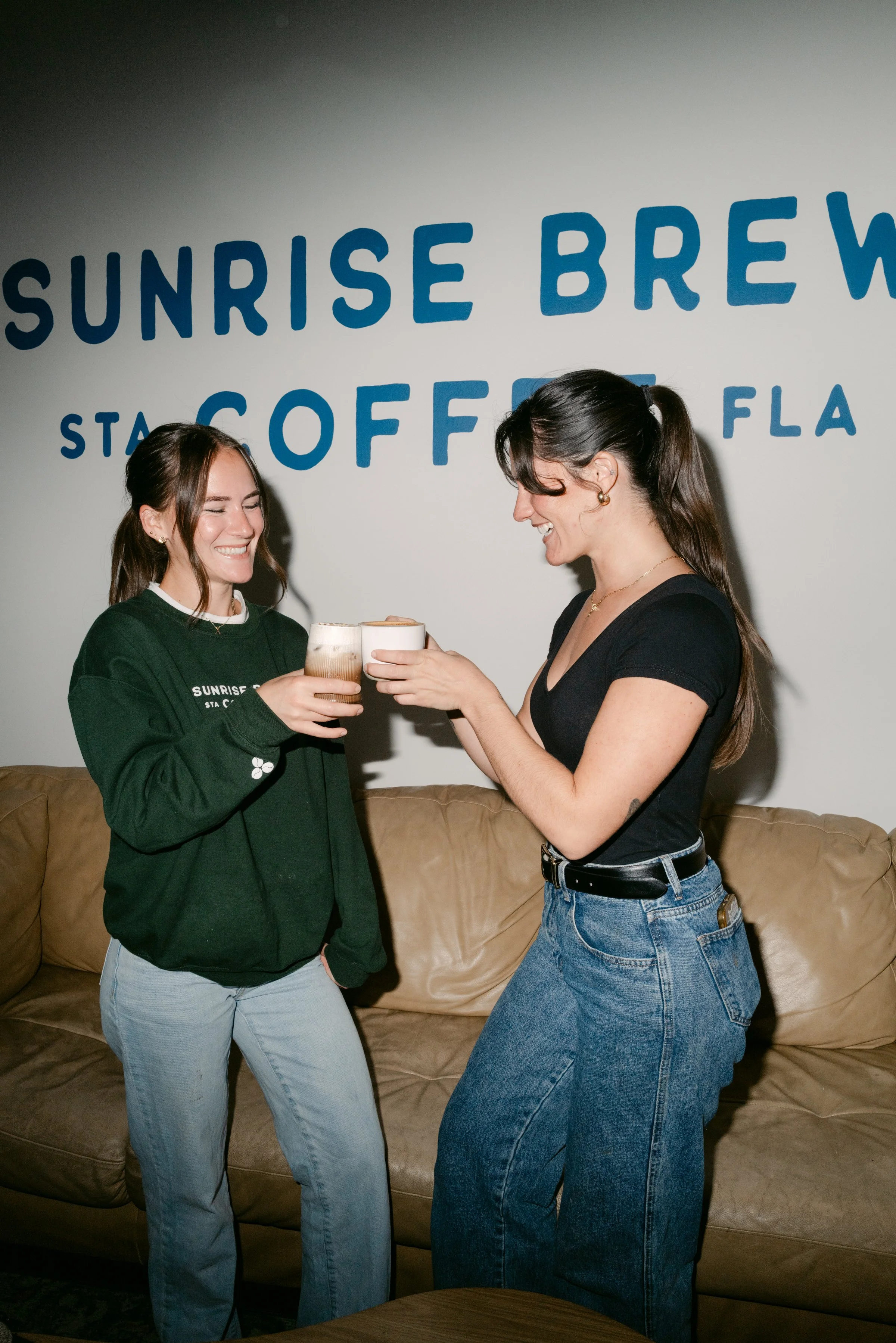 Maggie and Tessa together in black shirts inside Sunrise Brew