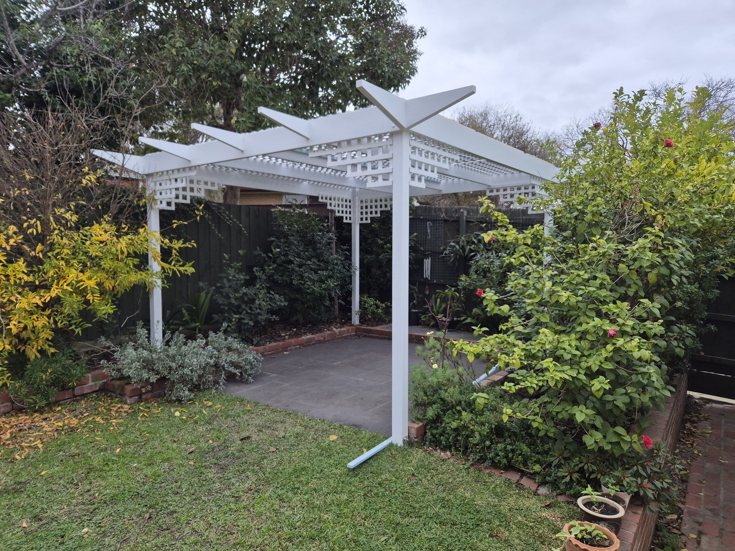 White garden pergola built by TJS Maintenance with decorative lattice detailing