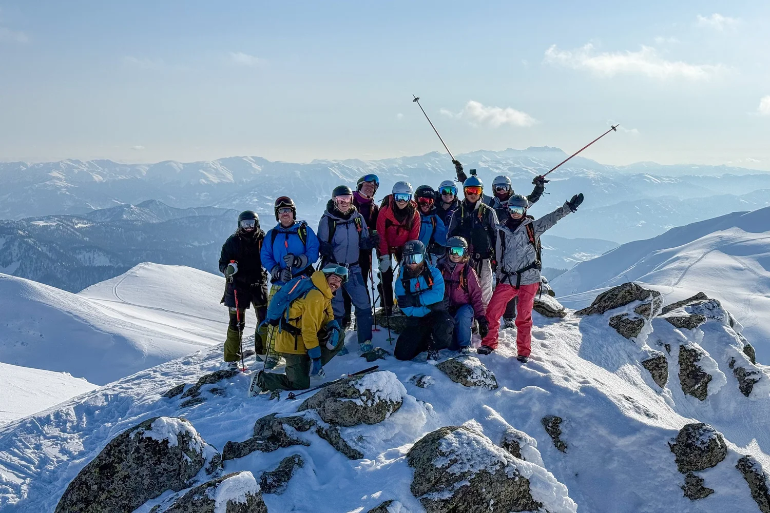Seekrs ski crew on a snowy summit