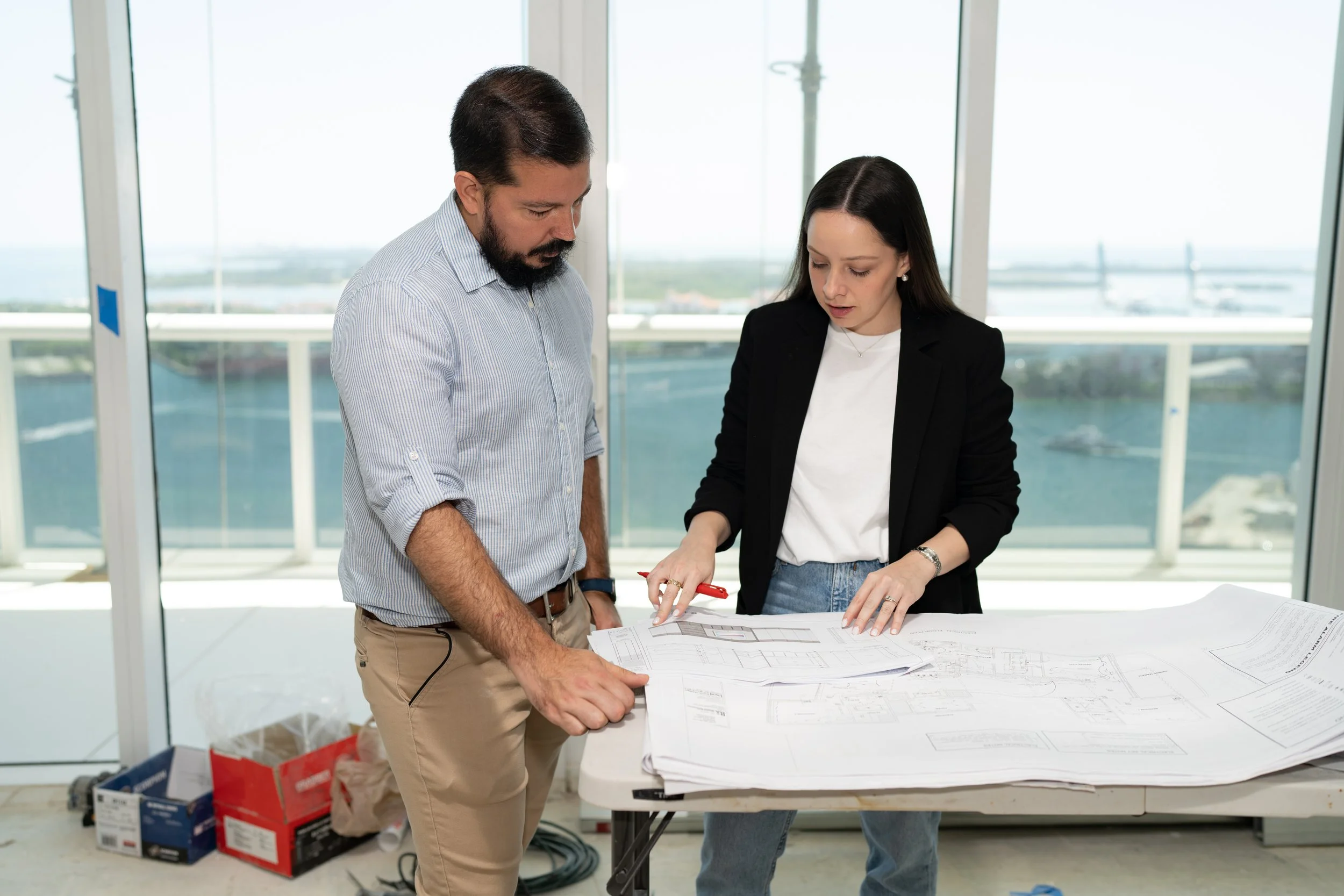 Miami interior designer Arianna Castro of Interiors by AC reviewing residential project plans on site