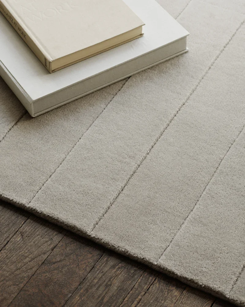 Neutral textured wool rug anchoring a refined living room seating area