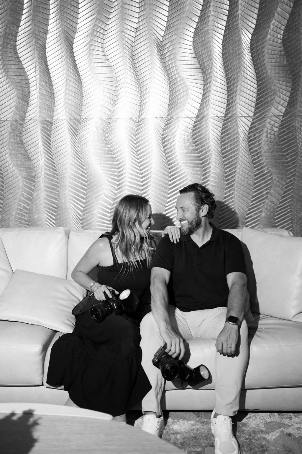 Jaclyn and Andrew smiling together with their cameras