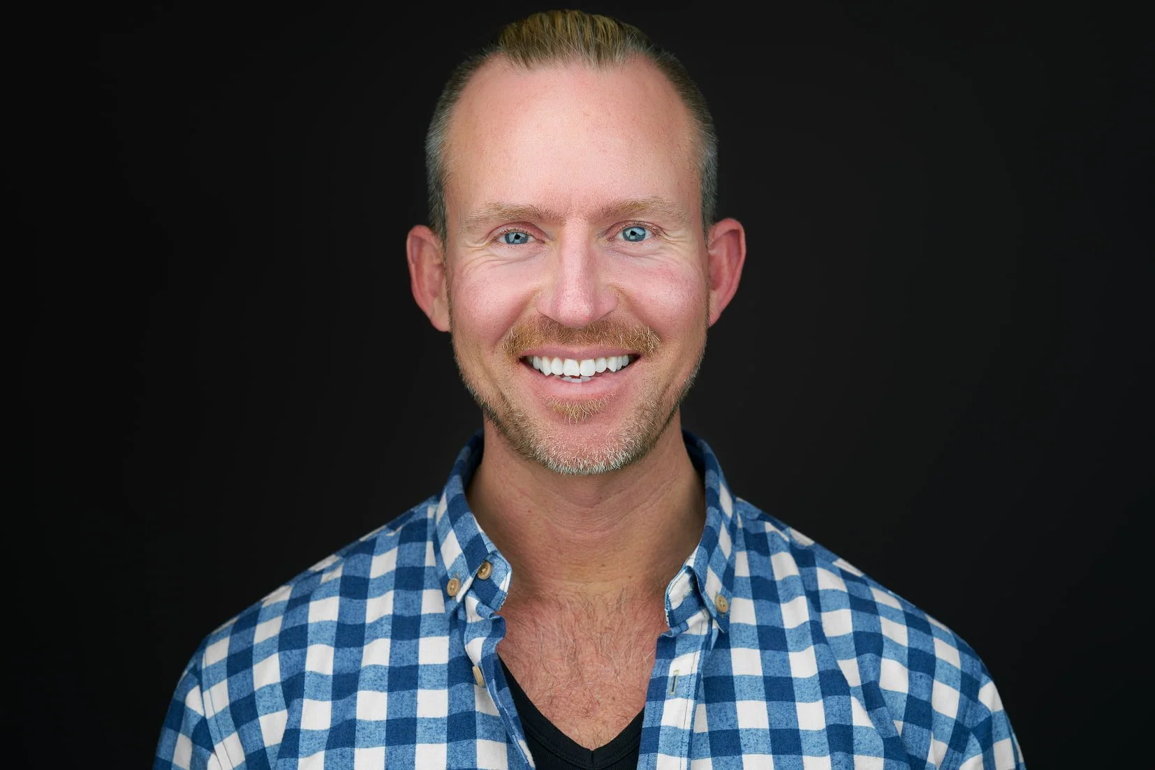 Professional headshot of Lasse on a dark backdrop, photographed at Maverick Studios in Edmonton