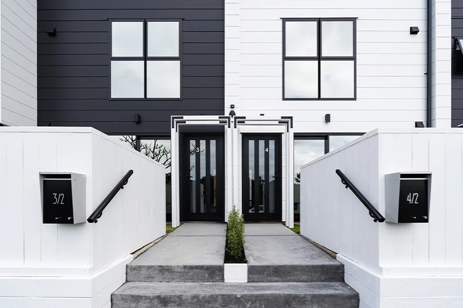 Paired entrances, white screens and contrasting cladding at 2 Jadewynn Drive, Massey