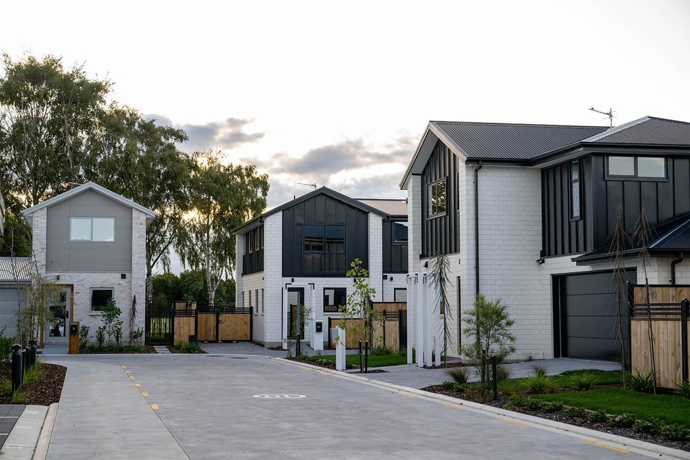 White brick and dark-clad homes along the landscaped lane at Mohua Lane, Christchurch