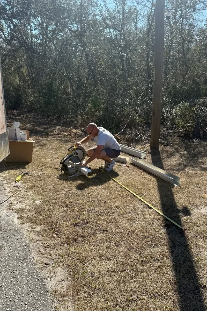 Danny cutting a downspout during a seamless gutter installation in Ocklawaha, Florida