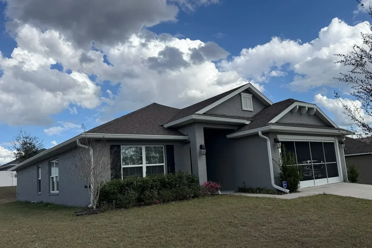 White seamless gutter installation on gray home in Dunnellon, Florida